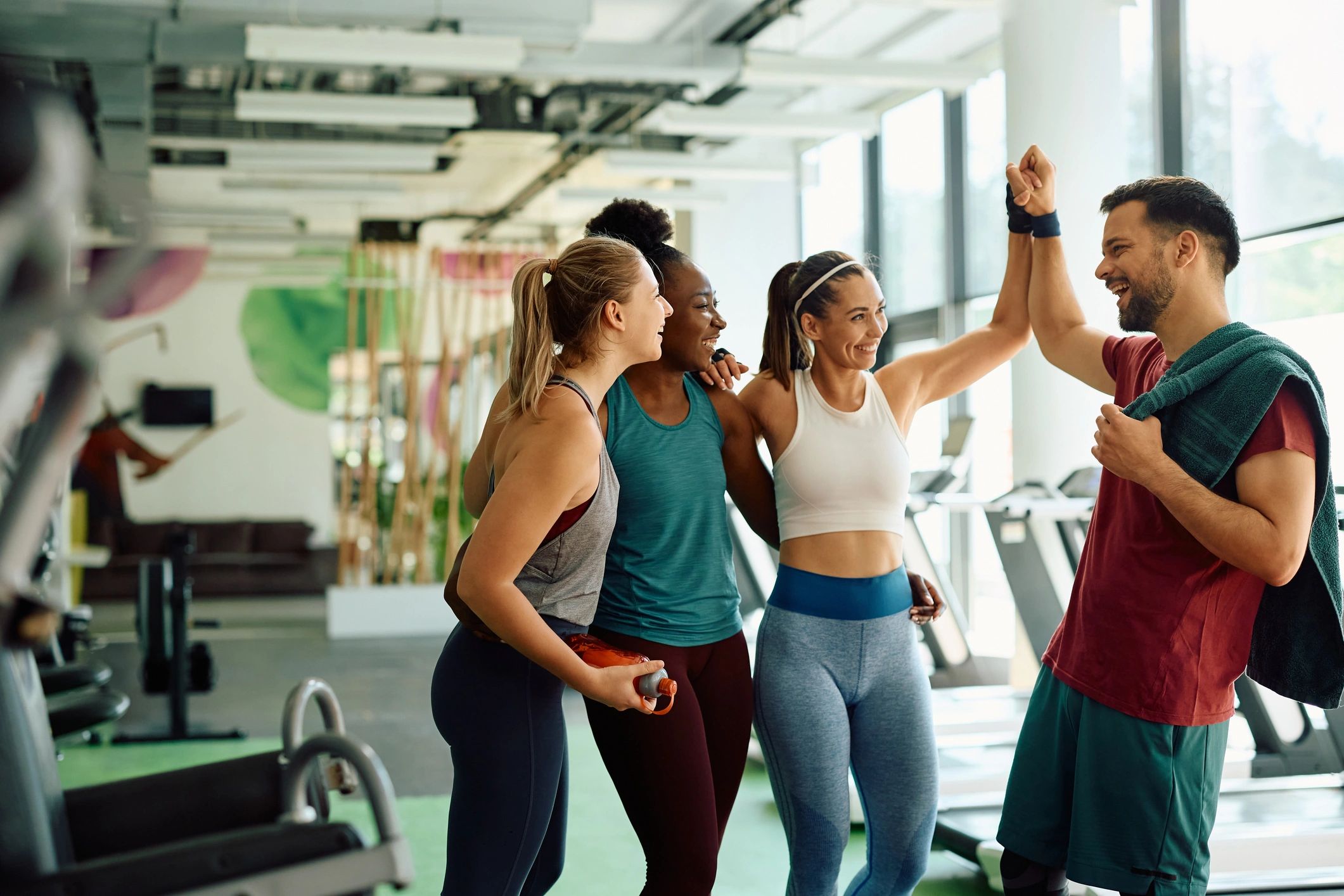 Happy athletic friends congratulating each other on successful workout